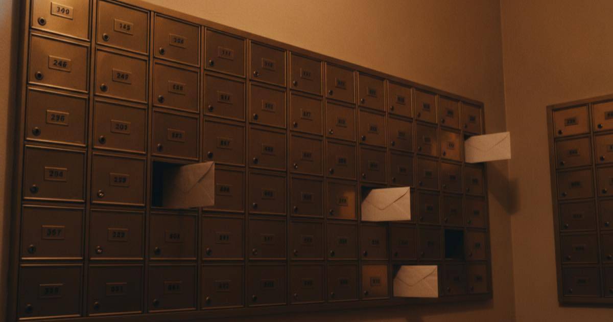 A wall of physical mailbox slots in a building lobby, each a separate compartment